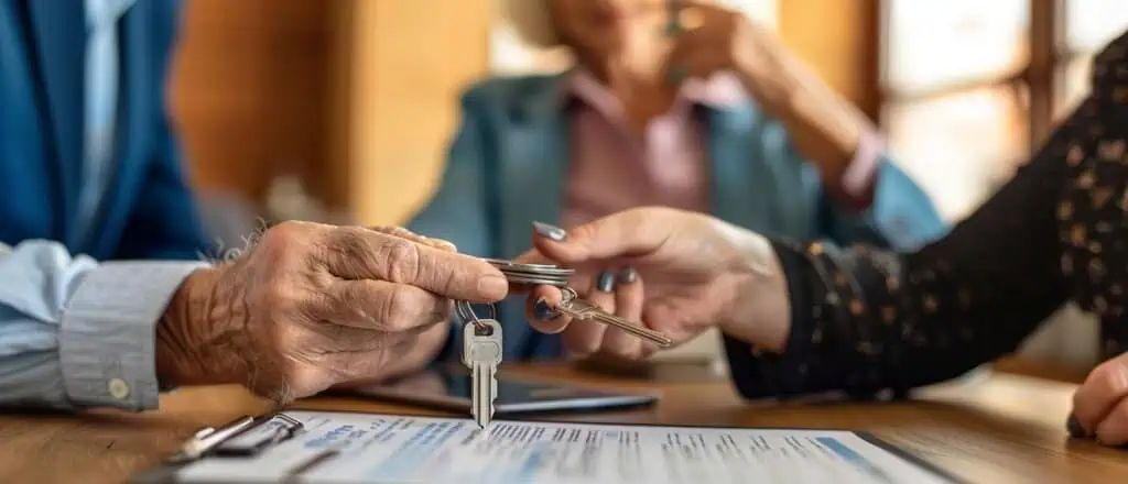 צילום יד של איש מבוגר שמעביר מפתח דירה ליד של אשה צעירה כחלק מהיתרונות של משכנתא הפוכה לצעירים